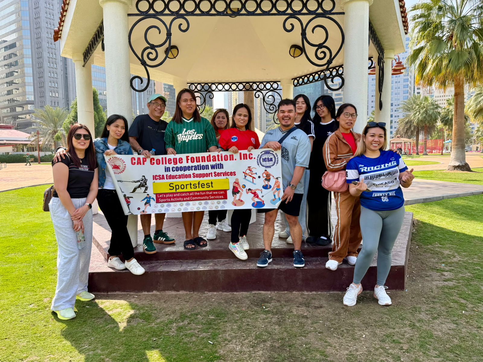 Sportsfest participants posing with a banner in a park pavilion