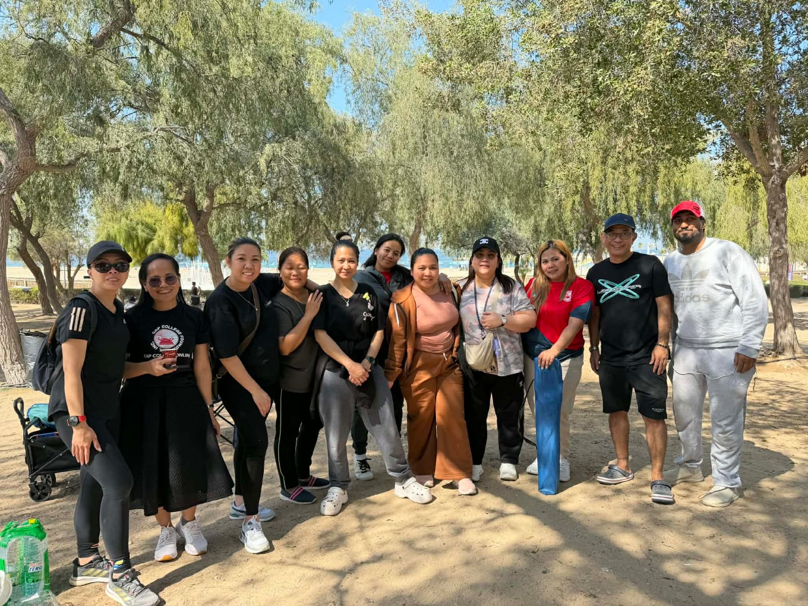 A larger group standing together under trees during an outdoor outing